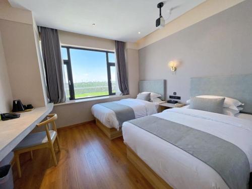 a hotel room with two beds and a window at 厦门中山海滨酒店 in Xiamen