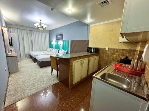 a room with a kitchen and a bedroom with a bed at Hafez Hotel Apartments - Al Ras Metro Station in Dubai
