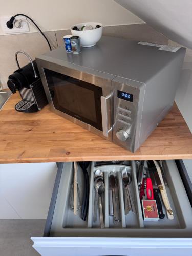 un four micro-ondes installé au-dessus d'une étagère dans l'établissement Studio agréable proche CHU, à Saleux