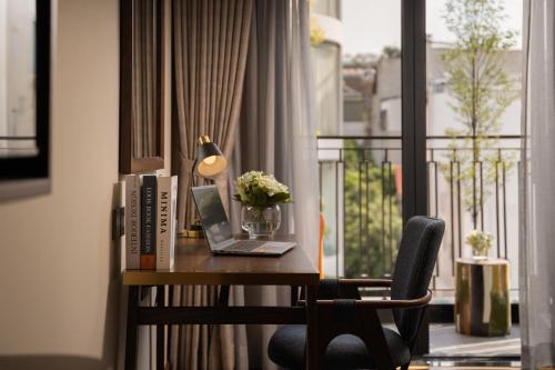 a desk with a laptop and flowers on a balcony at HOTEL de LAGOM in Hanoi