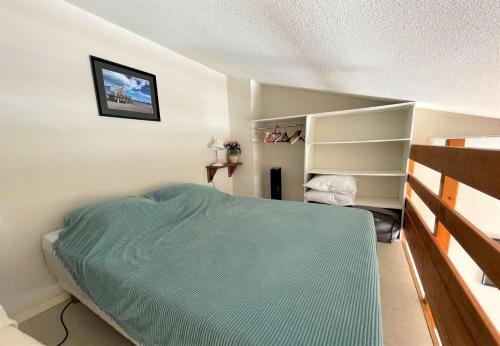 - une chambre avec un lit vert et une étagère dans l'établissement Maison Studio mezzanine - Gruissan GN510-019, à Gruissan