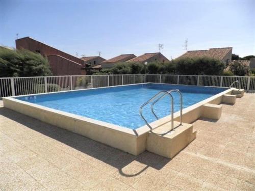 une grande piscine dans une cour dans l'établissement Maison Studio mezzanine - Gruissan GN510-019, à Gruissan