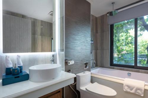 een badkamer met een wastafel, een bad en een toilet bij Oriana Hotel by OnHotelRooms in Vân Lũng