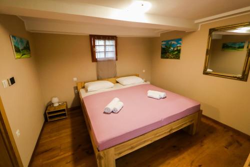 a bed in a room with two towels on it at Hostel Strug in Makole