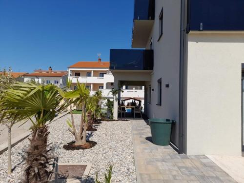 a white building with palm trees in front of it at Villa LuiSole in Krk