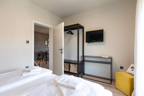 a bedroom with two beds and a television on the wall at Villa LuiSole in Krk