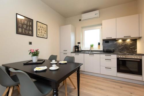 a kitchen with a black table and chairs in a room at Villa LuiSole in Krk