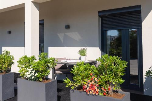 a patio with a table and potted plants at Villa LuiSole in Krk