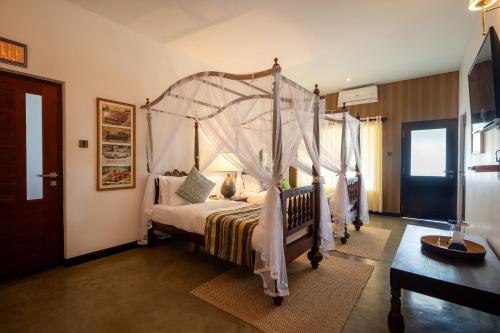 a bedroom with a four poster bed with a canopy at Riverdale Bungalow - Film Location For 'Bridge On The River Kwai' in Kandy