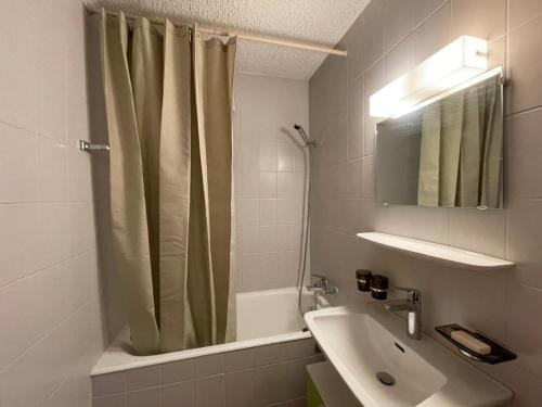 a bathroom with a shower curtain and a sink at Appart La Fouly in La Fouly