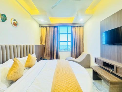 a bedroom with a large bed and a television at Hotel Lee Paramount in Gandhinagar
