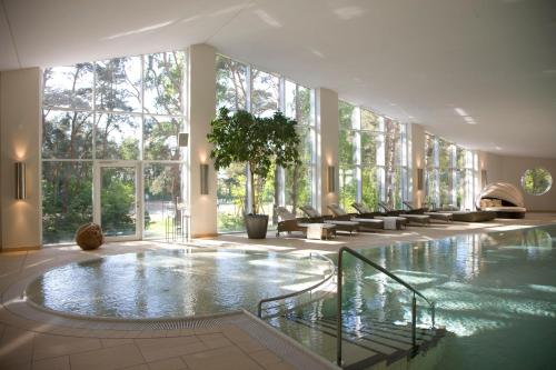 een groot zwembad in een gebouw met ramen bij Ferienwohnungen Fischland in Dierhagen