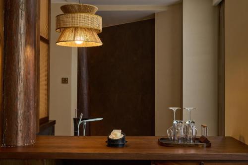 a dining table with glasses and a chandelier at ARULA J Hotel in Lijiang