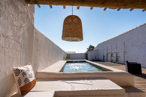 une lampe suspendue suspendue au-dessus d'une piscine dans l'établissement Maison en Camargue Les Saintes-Maries de la mer, à Maguelonne-la-Sauvage