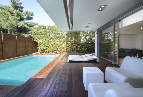 an indoor swimming pool in a house with a living room at Elegant and Private Living by Neuvel in Athens