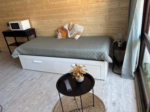 Cette chambre comprend un lit et une table avec télécommande. dans l'établissement Studio Tezoto, à Briançon