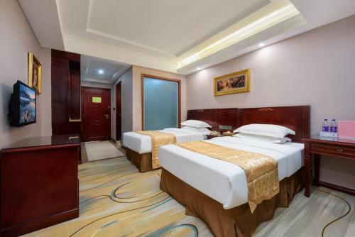 a hotel room with two beds and a television at Towo Hotel-Shenzhen Pingdi Branch in Shenzhen