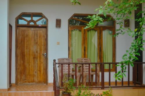 two doors and two chairs on a balcony at Glow Accommadation in Tangalle