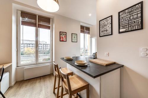 une cuisine avec une table et des chaises et une fenêtre dans l'établissement Le petit Barret du 8ème AIL, à Lyon