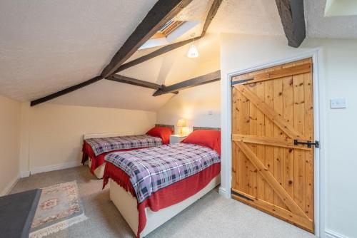a bedroom with two beds and a barn door at The Coach House in Abergavenny