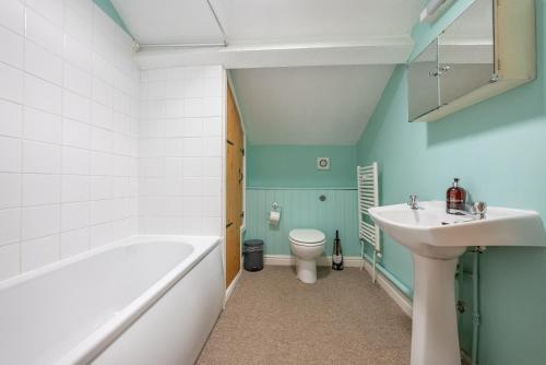 a bathroom with a tub and a sink and a toilet at The Coach House in Abergavenny