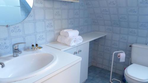 une salle de bain avec un lavabo, des toilettes et un miroir dans l'établissement Maison proche plage des Presses a Saint Philibert, à Saint-Philibert