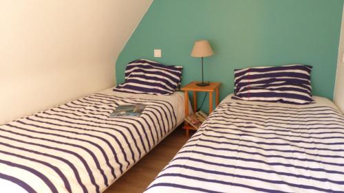 deux lits côte à côte dans une pièce dans l'établissement Maison proche plage des Presses a Saint Philibert, à Saint-Philibert