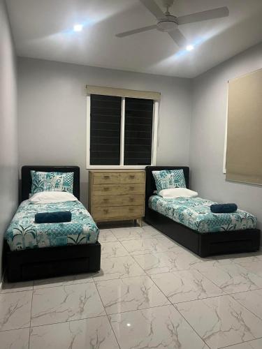 a bedroom with two beds and a window at Drydens Creek Retreat in Ngatangiia