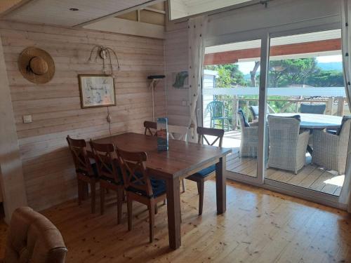 une salle à manger avec une table et des chaises en bois dans l'établissement GASMIM64 Chalet californien pour 6 personnes Proche St-Tropez, à Gassin