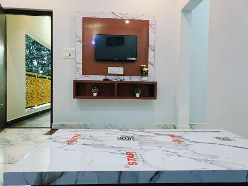 a room with a tv on a wall at Hilltop Heaven in Yelagiri
