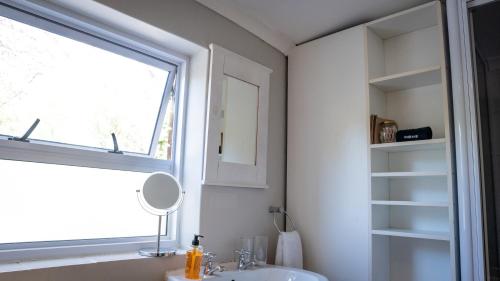 a bathroom with a sink and a window at Rustic Manor Guest House in Tokai