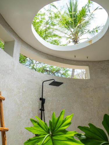 a circular skylight in a room with plants at Temple Point Resort in Watamu