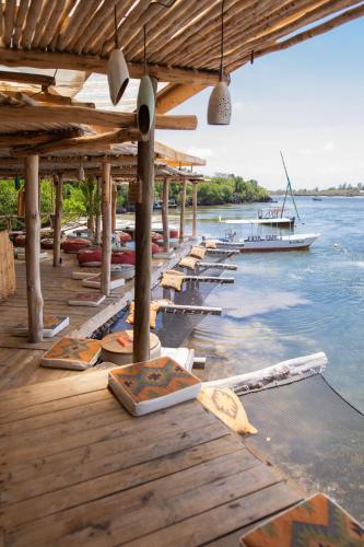 a row of boats on a dock on the water at Temple Point Resort in Watamu