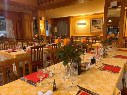 a dining room with tables with flowers on them at Hotel Breuil in Breuil-Cervinia