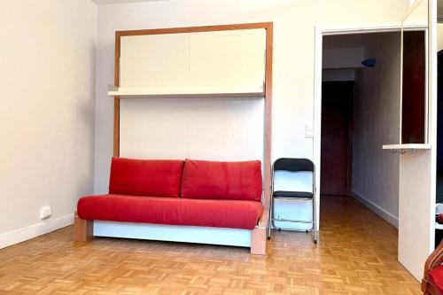 - un canapé rouge dans une chambre avec une étagère dans l'établissement Parc Monceau - Chez Amélie, à Paris