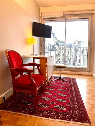 - un salon avec une chaise et un tapis rouges dans l'établissement Parc Monceau - Chez Amélie, à Paris