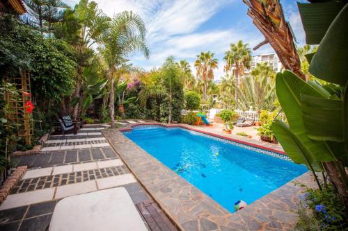 a swimming pool in a yard with palm trees at Majestic Villa by the Beach Heated Private Pool & Jacuzzi in Benalmádena