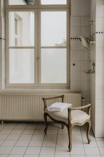 a bathroom with a bench and a window at B&B Kasteel Den Tip in Arendonk