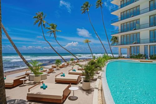 an image of a hotel with a swimming pool and the ocean at Radisson Collection Resort Galle in Galle