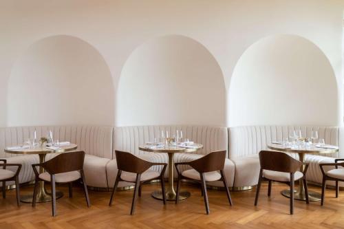 a dining room with tables and chairs and white walls at Radisson Collection Resort Galle in Galle