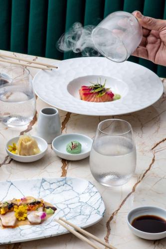 a table with plates of food and glasses of water at Radisson Collection Resort Galle in Galle