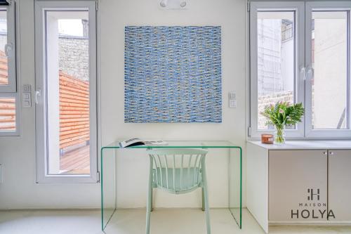 une table en verre et une chaise dans une chambre avec fenêtres dans l'établissement Proche Porte Maillot - Le Patio - 393B, à Neuilly-sur-Seine