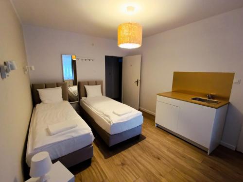 a room with two beds and a sink in it at Pensjonat Sokolec in Sokolec