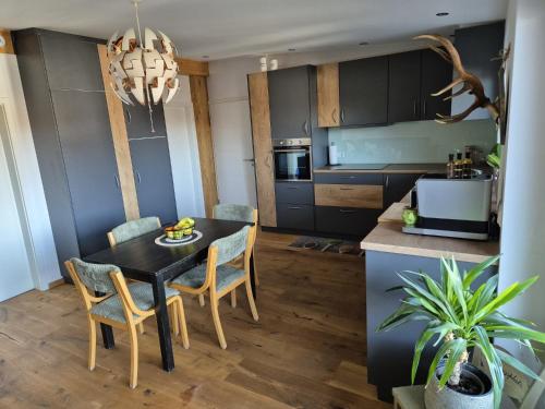 a kitchen with a dining room table and chairs at Ferienwohnung Mariposa in Böbing