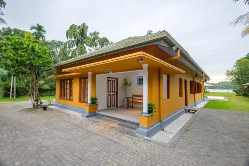a small house with a yellow at Ayuwaters Authentic Yoga and Ayurveda Retreat by the Bentota River All Inclusive in Bentota