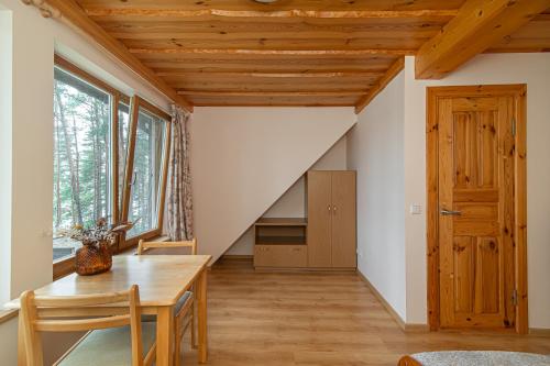 a dining room with a wooden table and a staircase at Villa Green in Molėtai