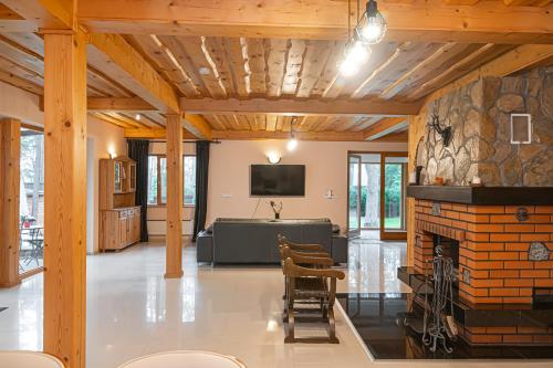 a living room with a fireplace and a tv at Villa Green in Molėtai