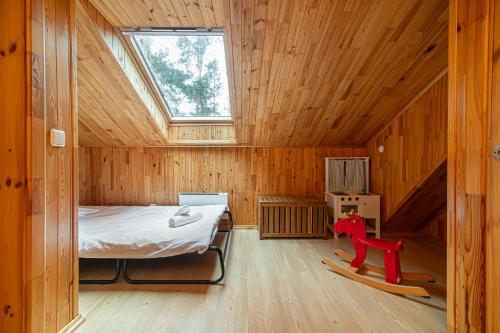 a small room with a bed in a wooden house at Villa Green in Molėtai