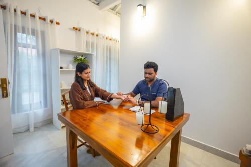 a man and woman shaking hands at a table at Ayuwaters Authentic Yoga and Ayurveda Retreat by the Bentota River All Inclusive in Bentota