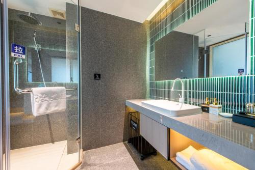 a bathroom with a sink and a shower at Calvin International Hotel Guangzhou Baiyun International Airport Huadu Plaza Branch - Free Deliver Service to Guangzhou Baiyun International Airport & Free Deliver Service to Canton Fair Complex During Canton Fair Period in Huadu